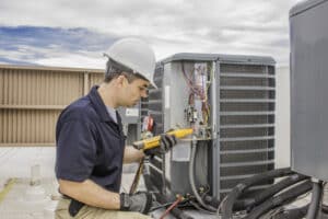 Technician performing maintenance on air conditioner